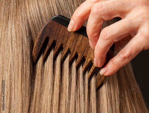 Female hand combing beautiful long hair