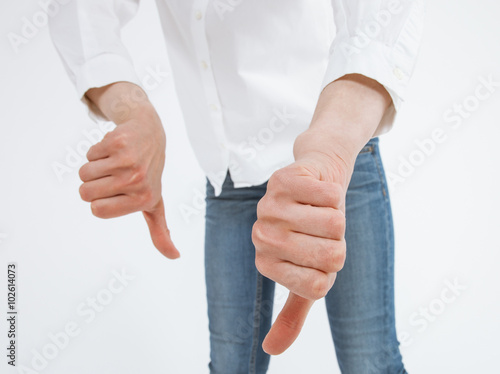 Unrecognizable young woman showing a thumb down sign