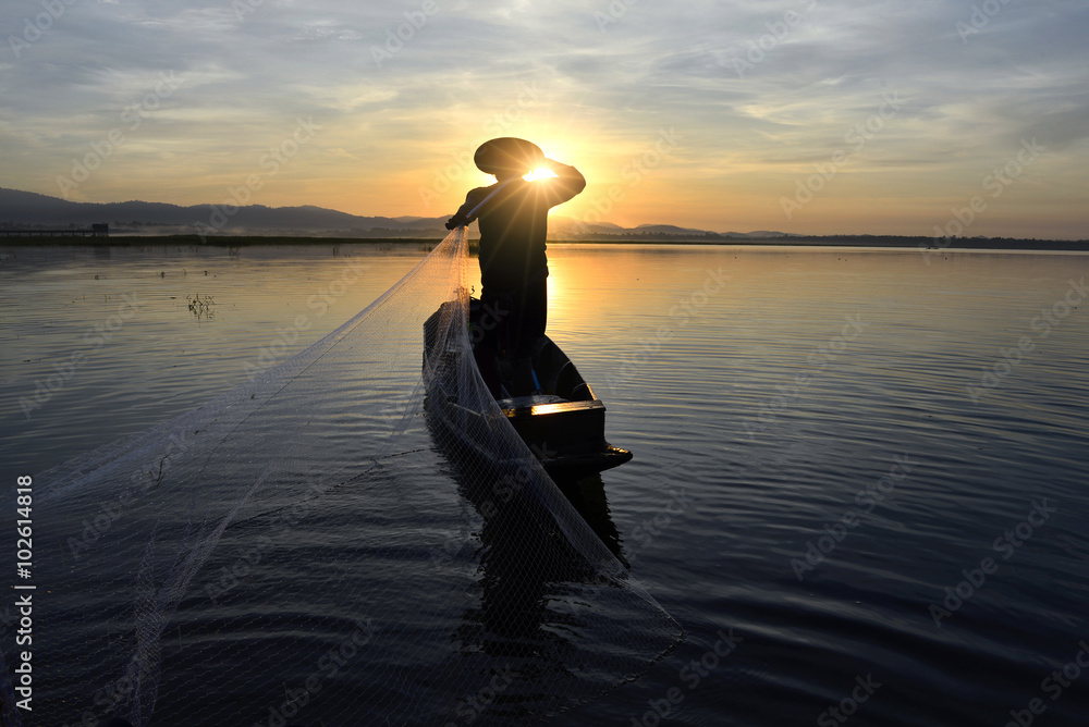 Silhouettes of the traditional stilt fishermen at sunset 