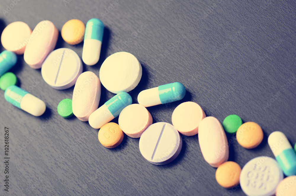 Pharmacy background on a black table. Tablets on a black background. Pills. Medicine and healthy. Close up of capsules. Pharmacy background on a black table. Tablets on a black background. Pills. Medicine and healthy. Close up of capsules.