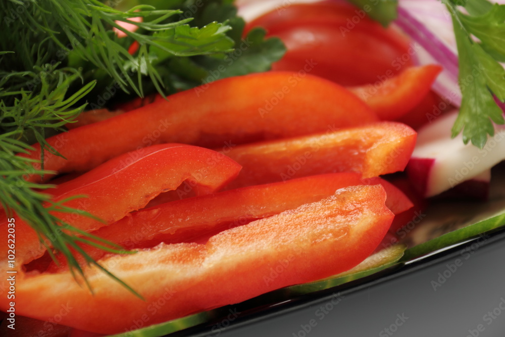 Sliced peppers. / Bulgarian pepper on a black dish with radish, cucumber and dill. Sliced peppers. / Bulgarian pepper on a black dish with radish, cucumber and dill.