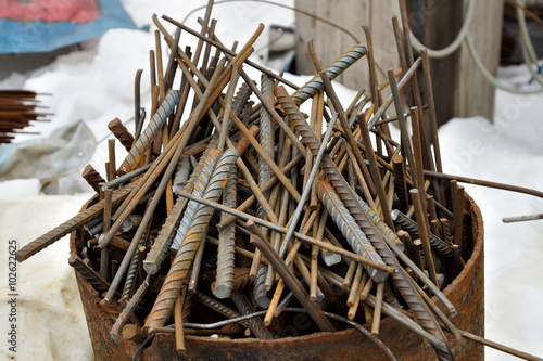 Trim metal rods in a metal barrel.