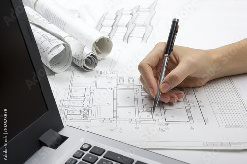 Architect working on blueprint. Architects workplace - architectural project, blueprints, ruler, calculator, laptop and divider compass. Construction concept. Engineering tools