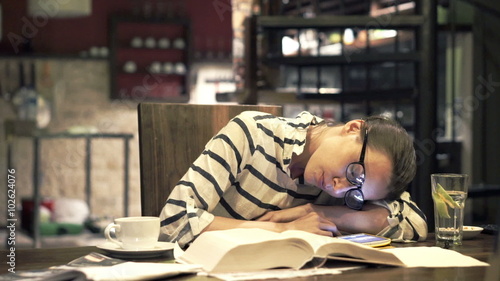 Tired woman sleeping by table at home at night
