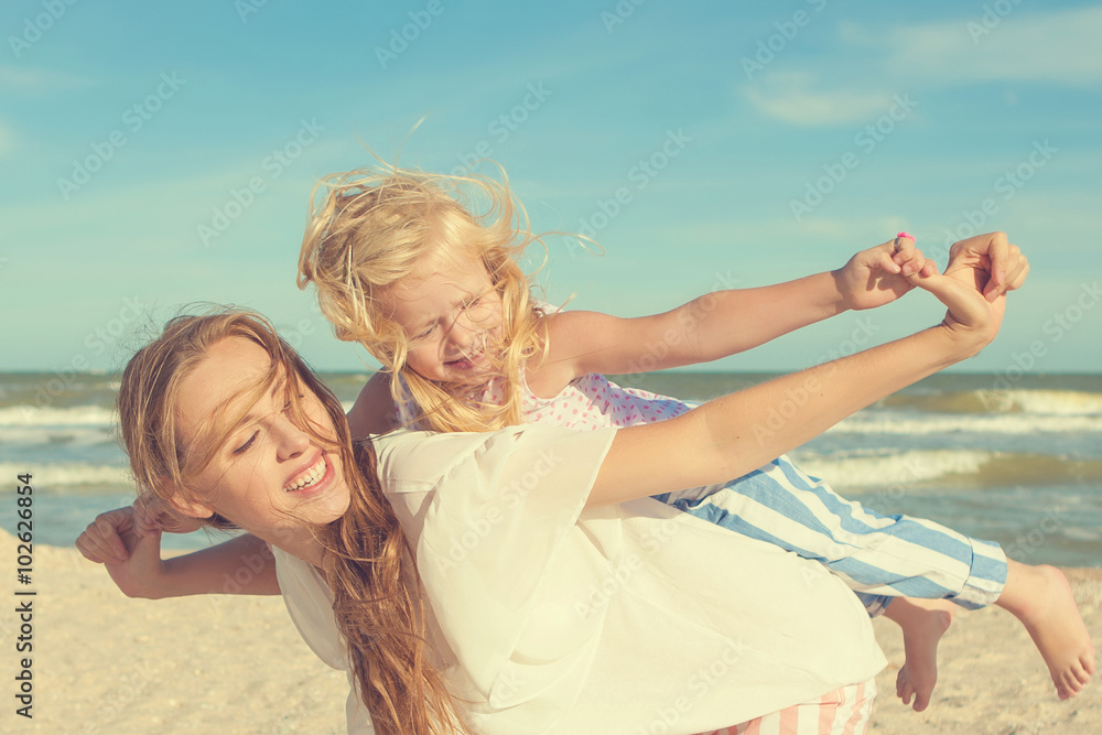 Mother and her daughter having fun on the beach Mother and her daughter having fun on the beach