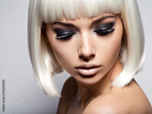 The girl's face closeup with long black lashes. fashion makeup