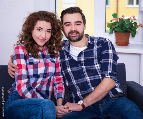 portrait of cute young couple sitting in living room