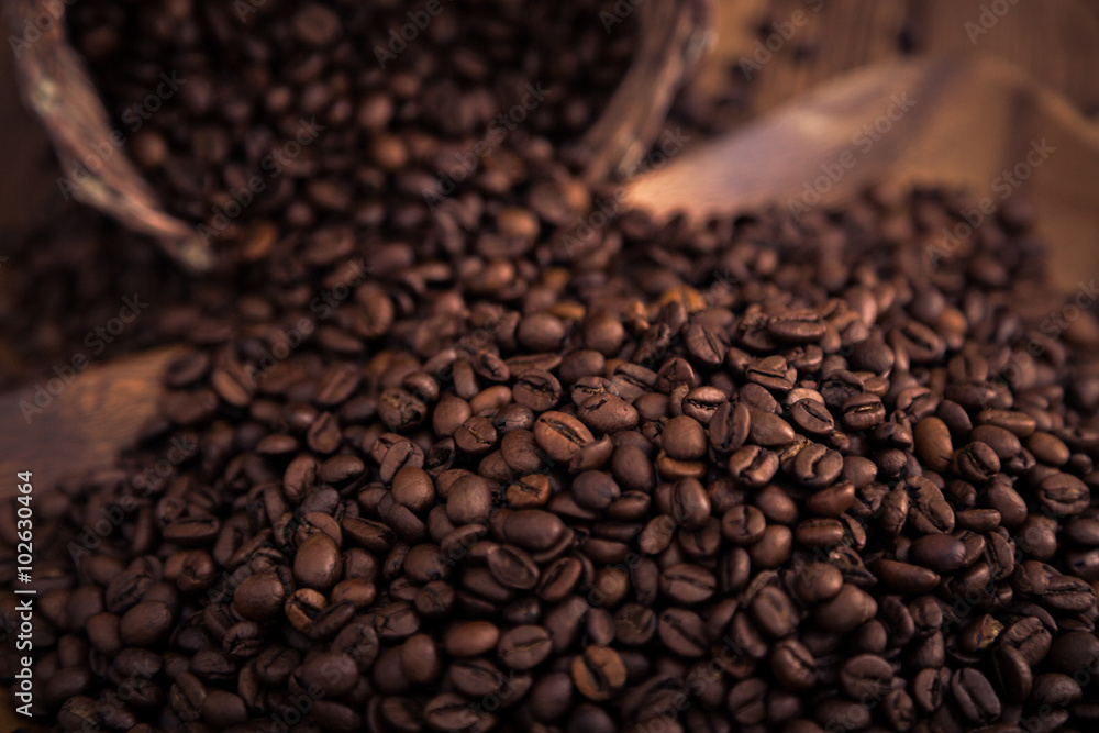 Fototapeta premium Roasted coffee beans close-up on a wooden surface