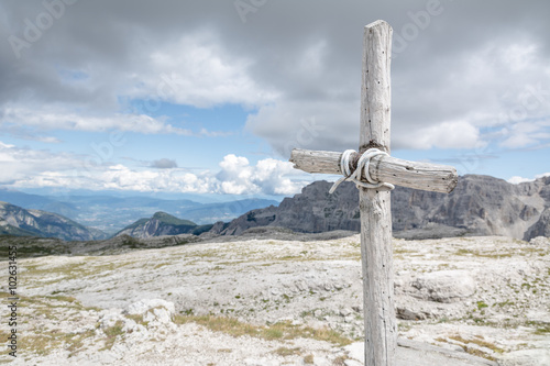 Croce grezza con montagne e cielo sullo sfondo photo