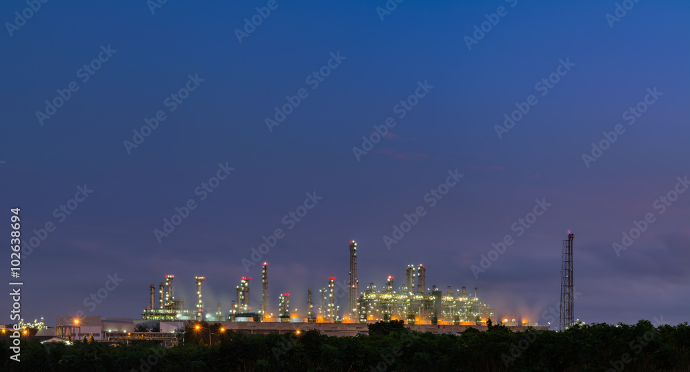Industrial plant among green environment, in night time.