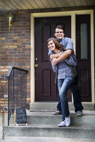 couple outside of new home celebrating new purchase