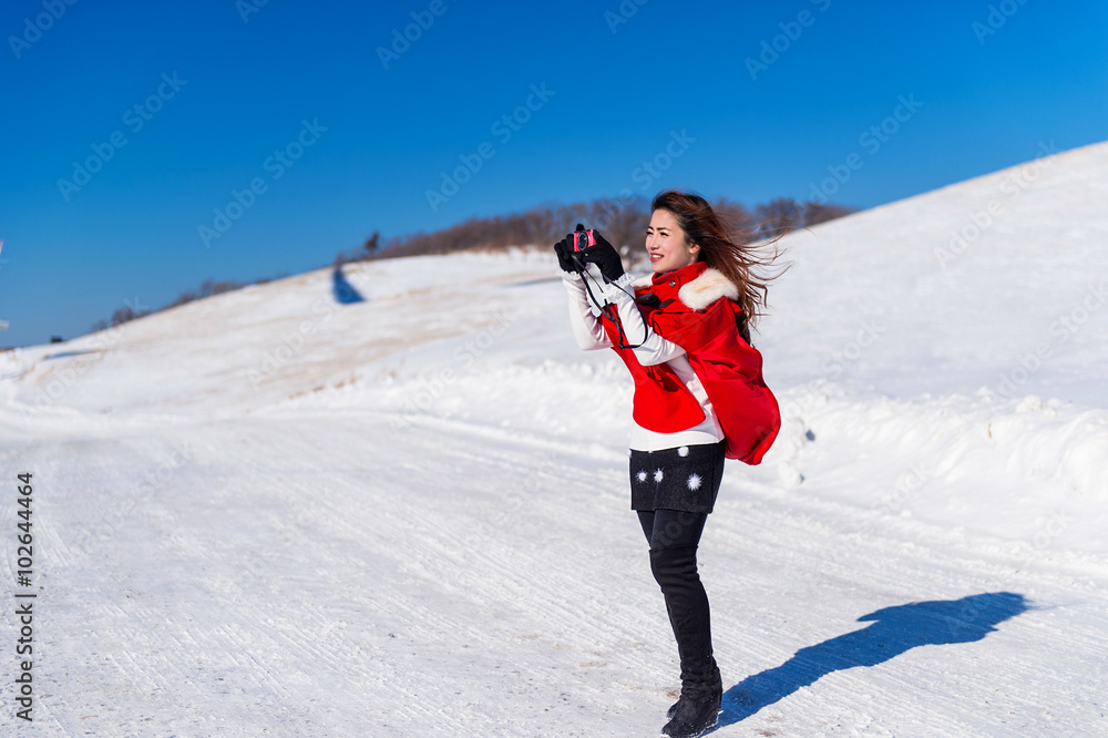 Young woman is a happiness with camera in winter of sky and wint