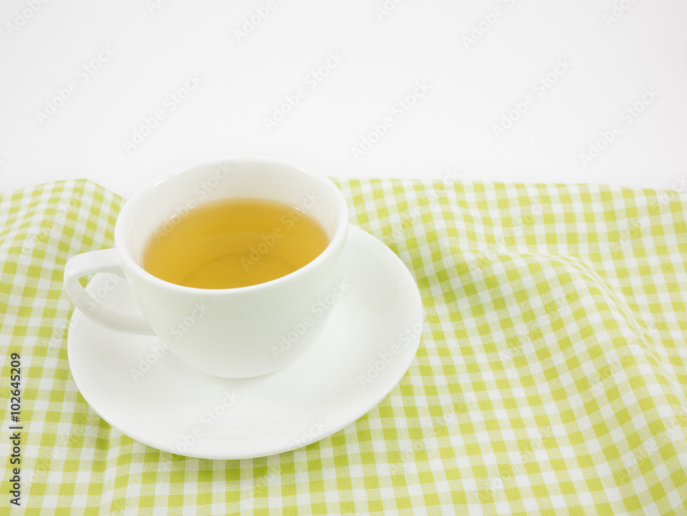 The cup of Japanese green tea on green cotton fabric. The cup of Japanese green tea on green cotton fabric.