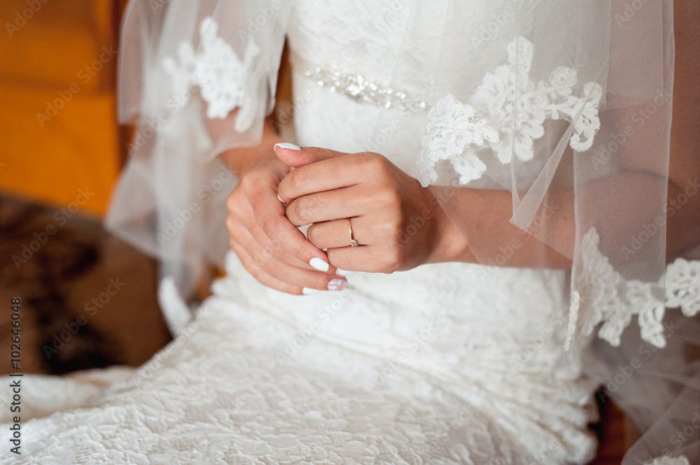 Tender beautiful bride's hands on elegant white wedding dress Tender beautiful bride's hands on elegant white wedding dress