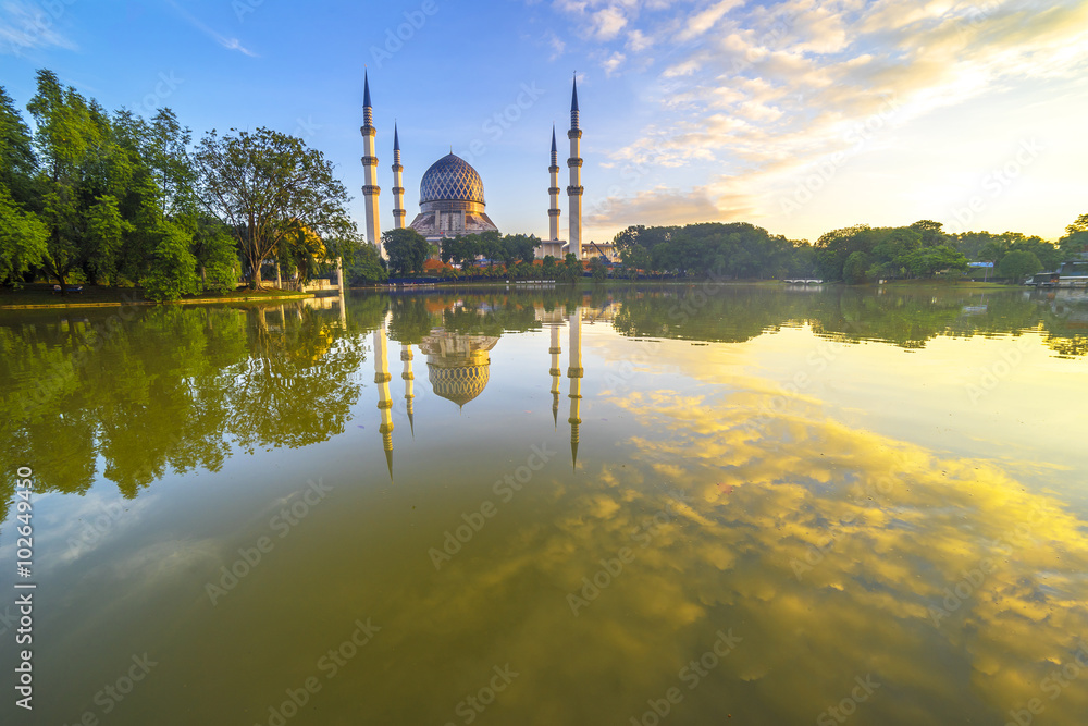 The Beautiful Sultan Salahuddin Abdul Aziz Shah Mosque (also known as the Blue Mosque) with nature sunrise lighting and reflection..