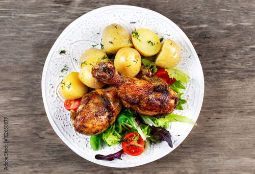 Baked chicken legs with potatoes and vegetables
