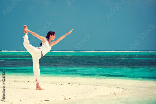 Canvas Print Slim girl  making yoga on the sea sand