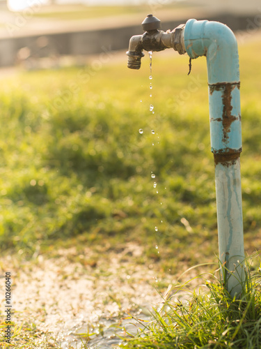 Old and dirty Brass water tap in nature background.