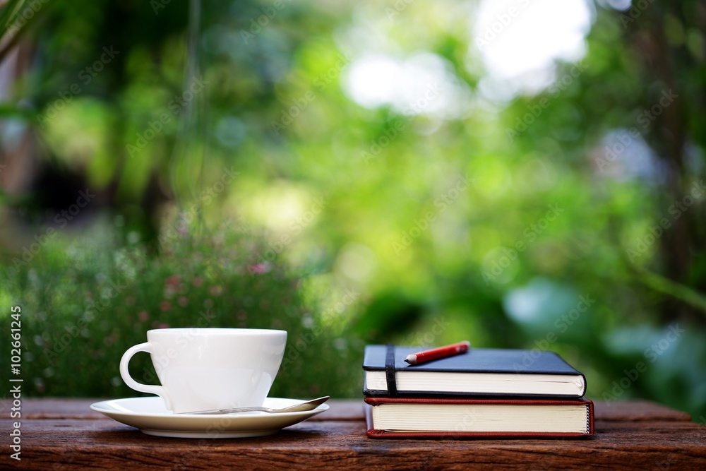 Notebook with pencil and cup on wooden table Notebook with pencil and cup on wooden table