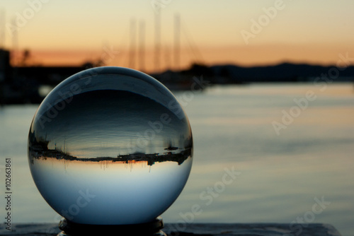Crystal ball images with boats and sunset in background © bellass