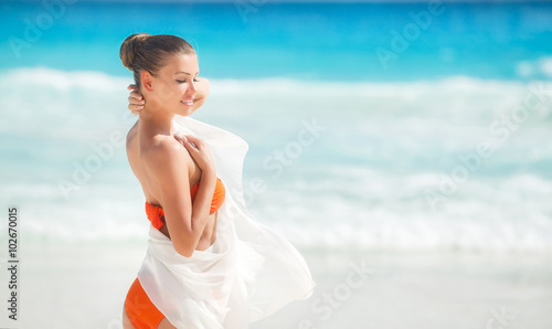 Beautiful woman on the beach in orange bikini