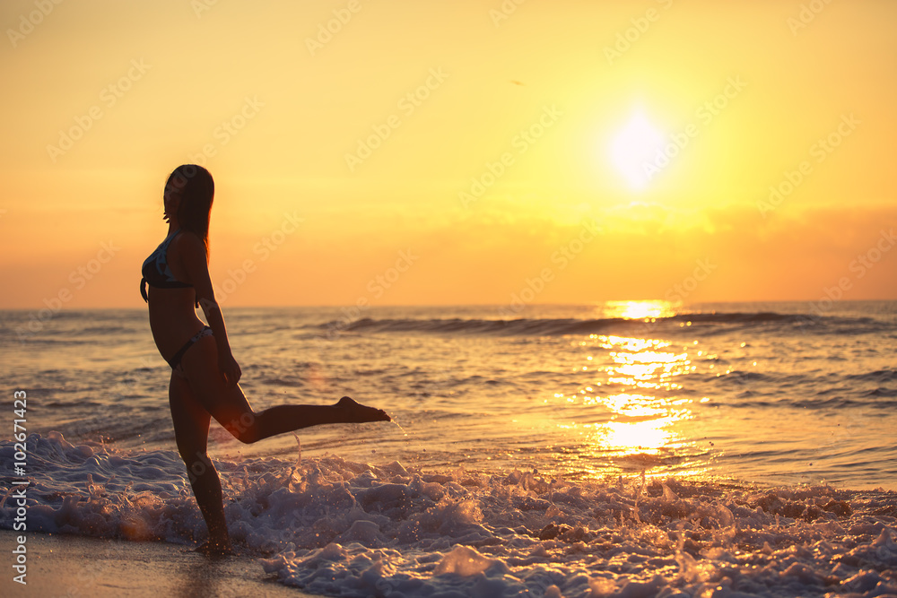 Silhouette of carefree woman on the beach