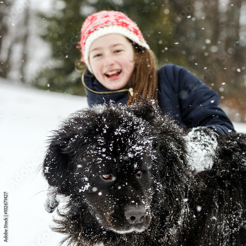 Children playing with big water-dog in snow photo