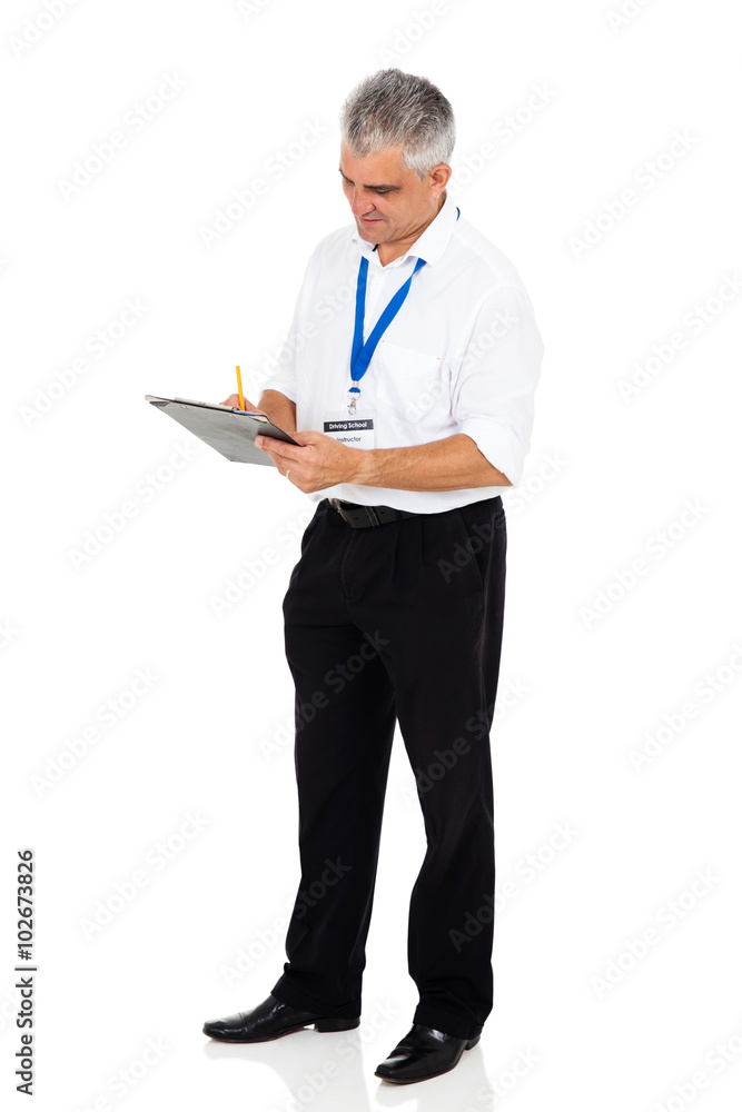 senior driving instructor writing on clipboard senior driving instructor writing on clipboard