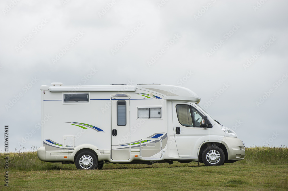 Wohnmobil steht auf grüner Wiese