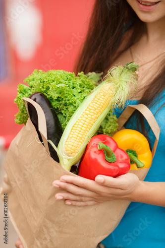 Woman with vegatables at shopping mall girl at super market hold food photo