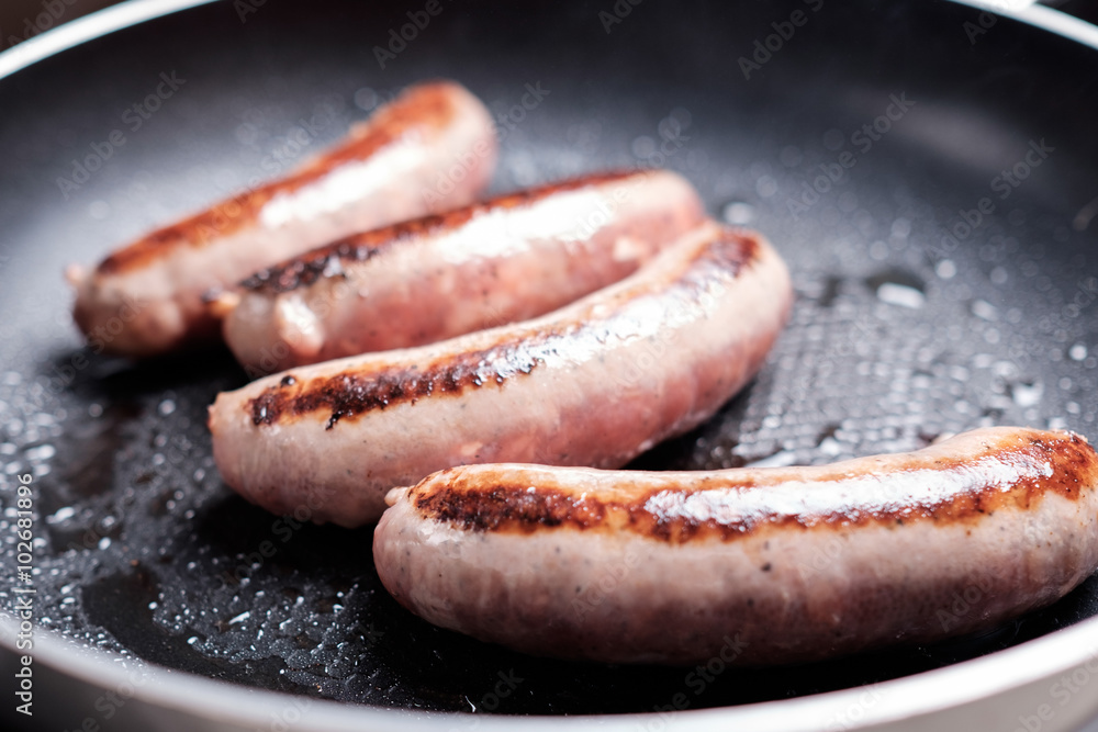 Cooking sausages in the dripping pan with oil Cooking sausages in the dripping pan with oil