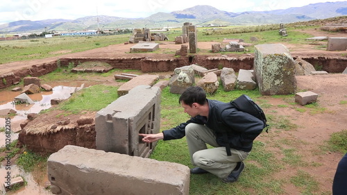 Man is looking at megalithic stones in the complex Puma Punku near Tiwanaku, Bolivia photo