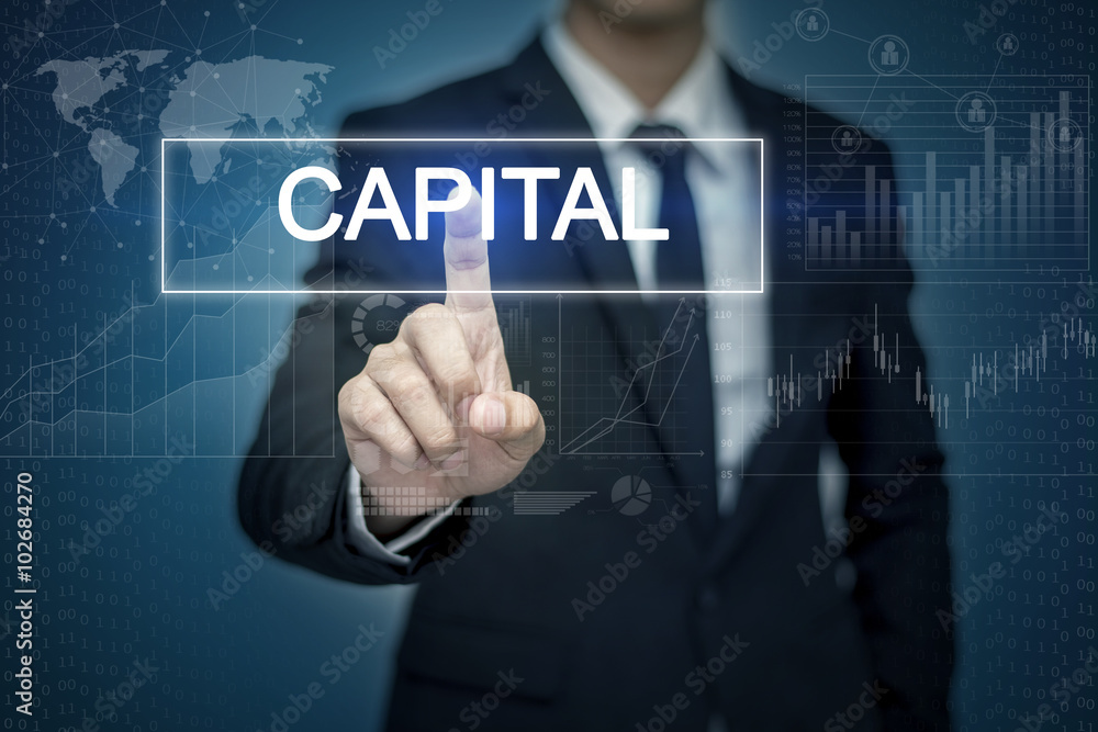 Businessman hand touching CAPITAL button on virtual screen Businessman hand touching CAPITAL button on virtual screen