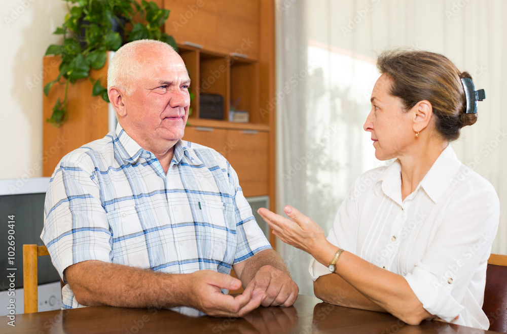 Serious couple talking in home interior