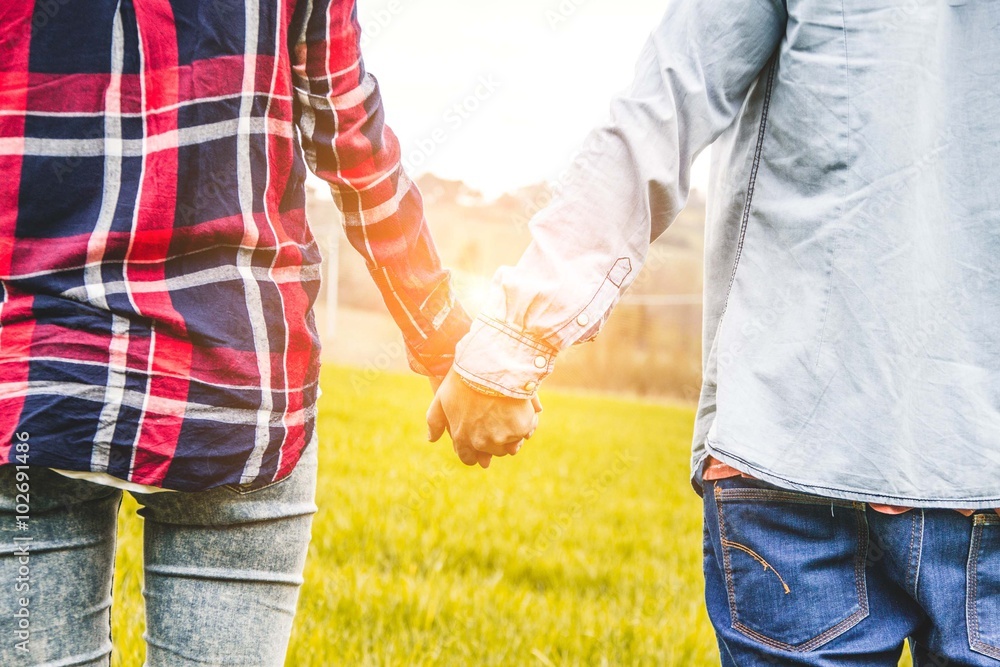 close-up of clasped hands of a loving couple in the country -lifestyle, people and outdoor concept close-up of clasped hands of a loving couple in the country -lifestyle, people and outdoor concept