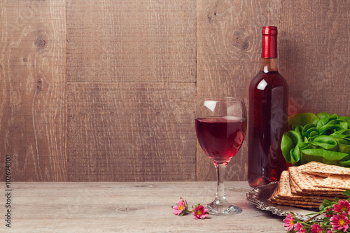 Passover celebration with wine and matzoh over wooden background