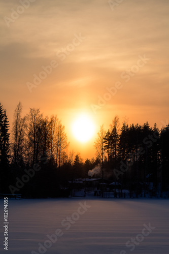 Orange sunset on the lake in Finland in the winter © tenrec