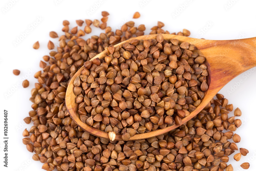 Fototapeta premium Uncooked buckwheat on wooden spoon