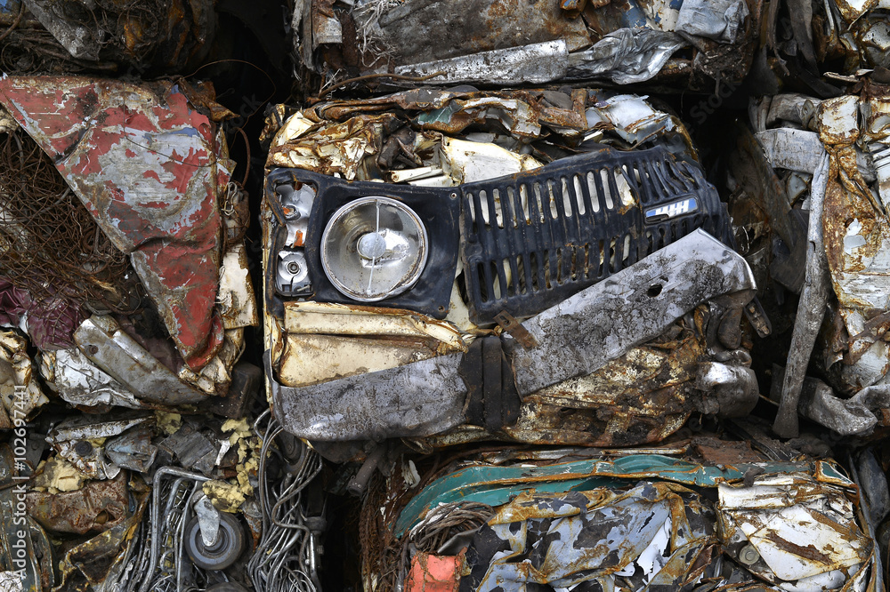 Fototapeta premium A pile of compressed cars in blocks for processing