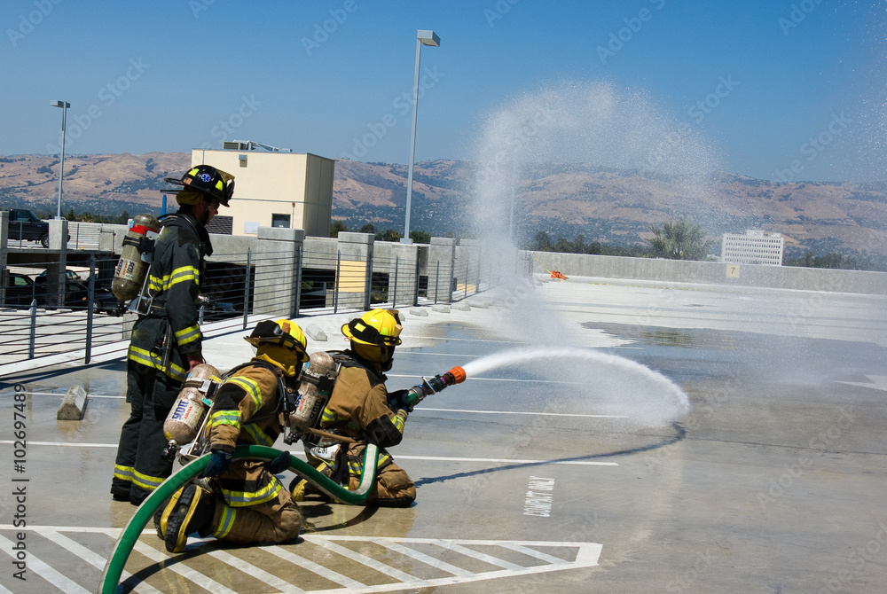 Obraz premium Firefighters training for fire with water hose