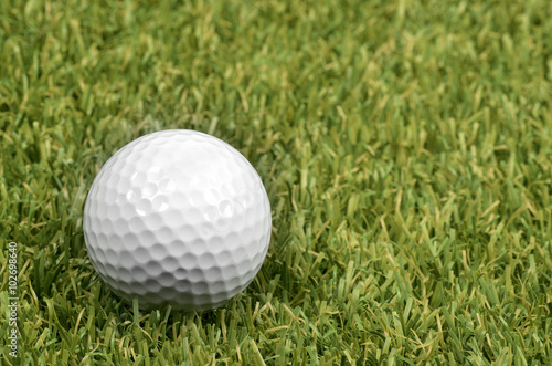 Golf ball on course with green grass.