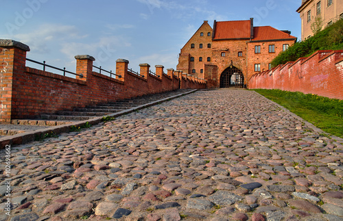 Paved street and the Gothic city gate in Grudziadz in Poland.