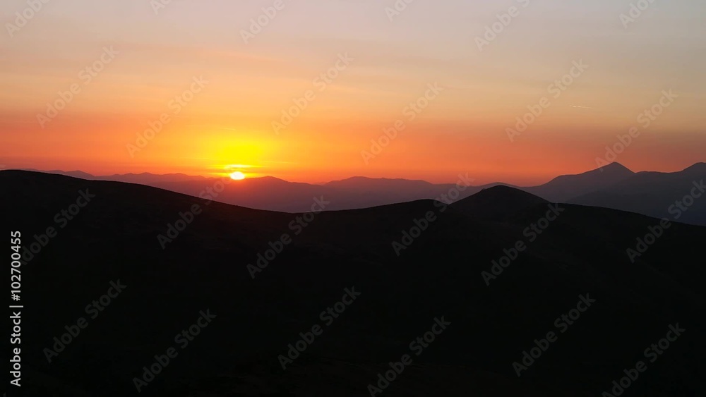 Brilliant summit dawn above flowing cloud waves, red sun disk time lapse Brilliant summit dawn above flowing cloud waves, red sun disk time lapse