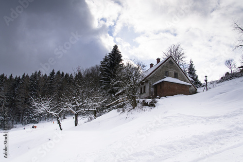Snow covered house in a frosty mountains country in sunny winter day © josefkubes