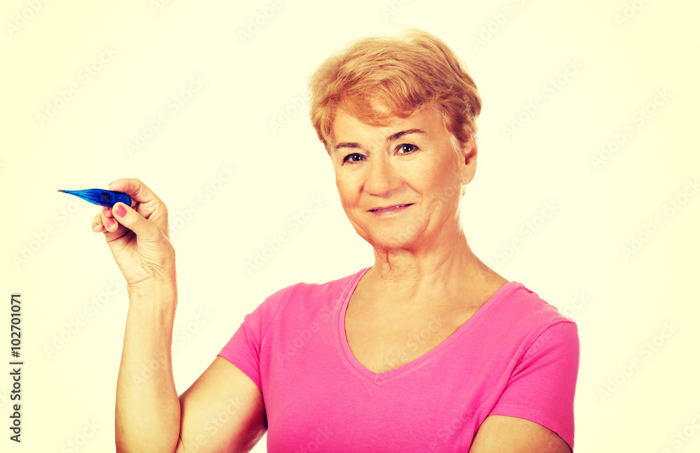 Smiling senior woman shows thermometer Smiling senior woman shows thermometer