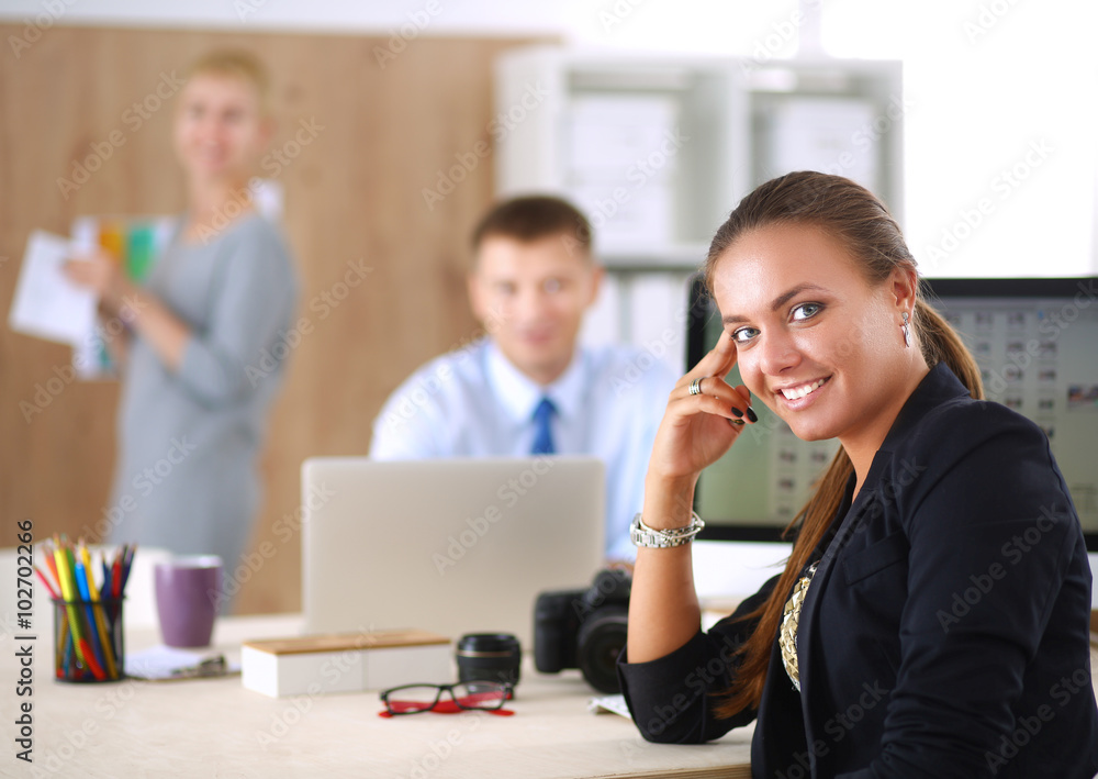 Young woman working in office, sitting at desk Young woman working in office, sitting at desk