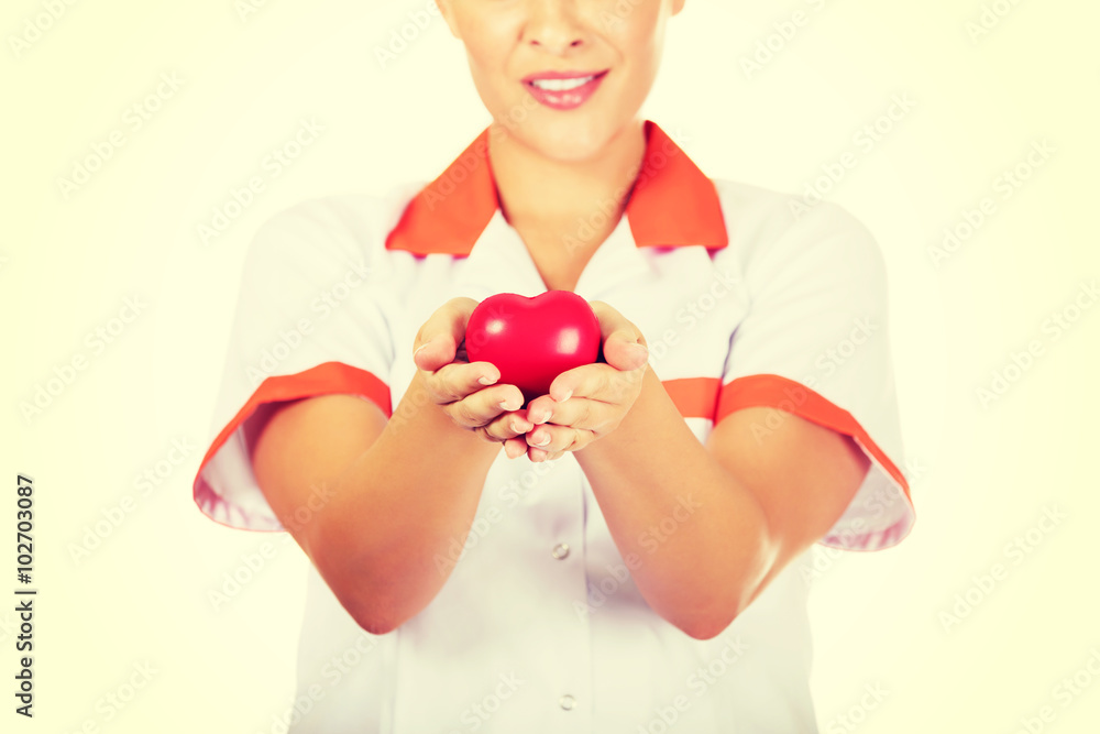 Young female doctor or nurse holding toy heart Young female doctor or nurse holding toy heart