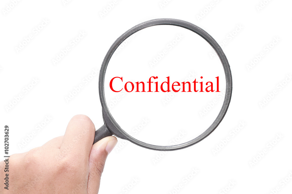 Hand showing Confidential word through magnifying glass. Magnifying glass search concept. Isolated on white background. Hand showing Confidential word through magnifying glass. Magnifying glass search concept. Isolated on white background.
