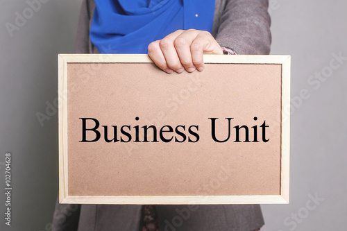 Businesswoman holding a softboard written Business Unit photo