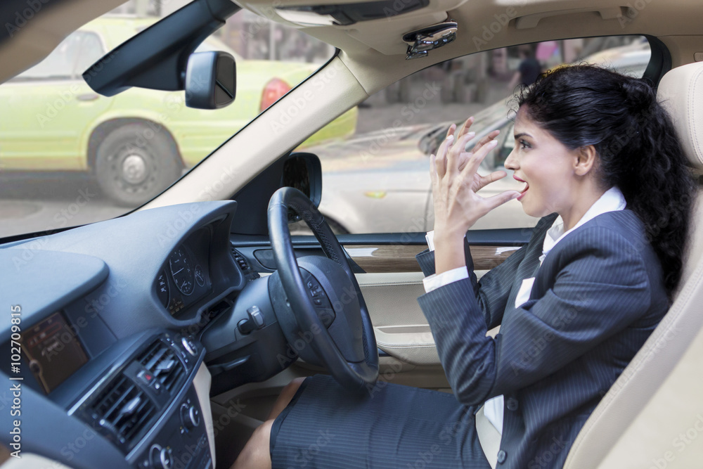 Furious indian businesswoman driving car Furious indian businesswoman driving car